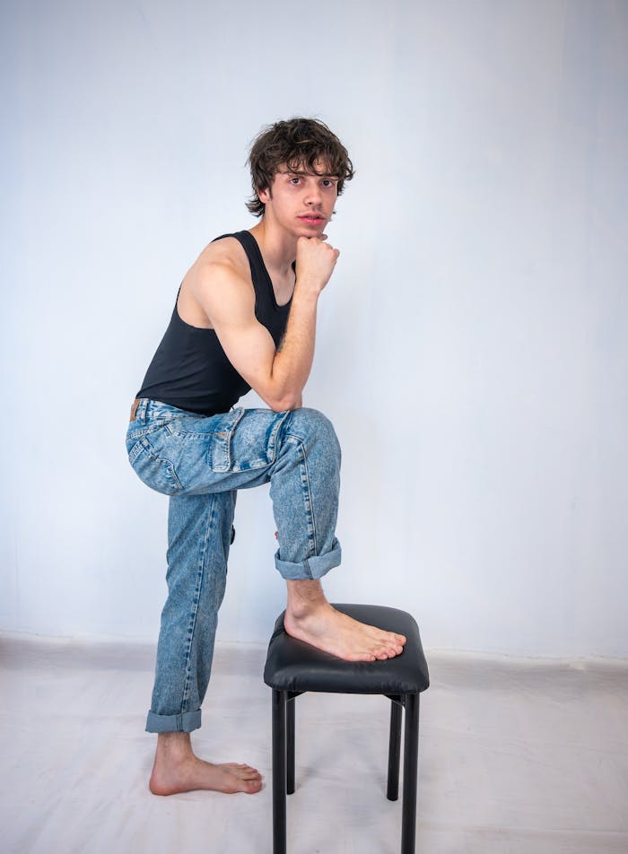Young male model in casual pose at a studio. Perfect for fashion and lifestyle themes.